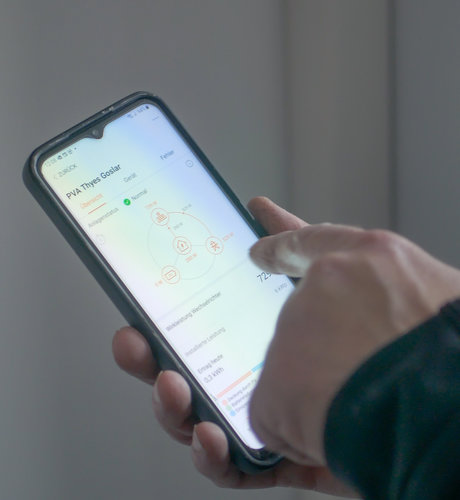 Finger zeigend auf Smartphone zur Auswertung der Wallbox